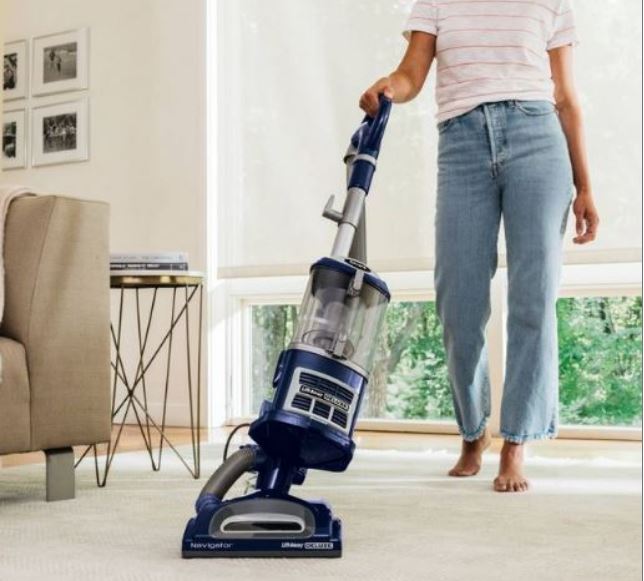 Woman vacuuming with the Shark Navigator Deluxe vac